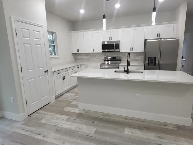 a kitchen with stainless steel appliances a refrigerator sink and stove