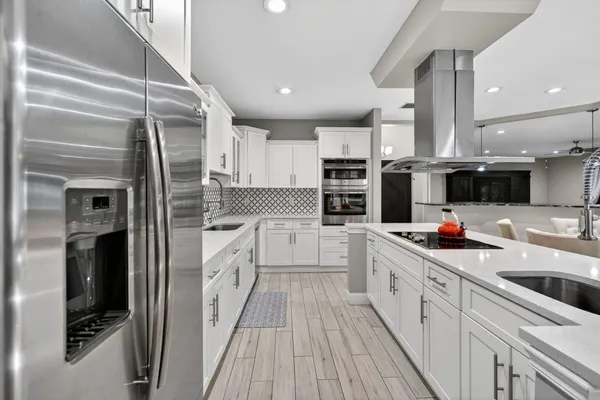 a kitchen with stainless steel appliances kitchen island granite countertop a sink cabinets and wooden floor
