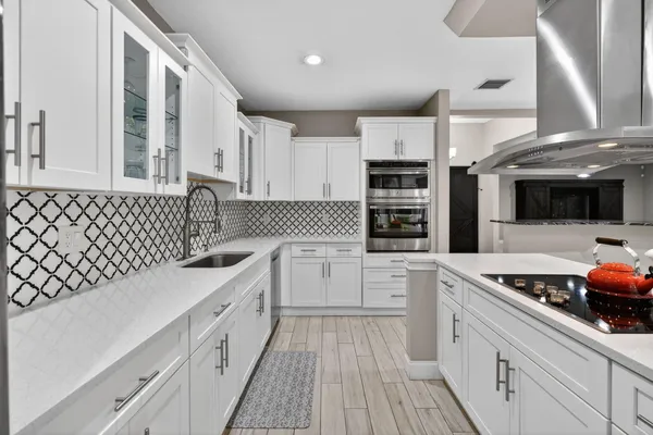 a kitchen with stainless steel appliances a sink stove and cabinets