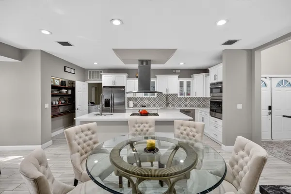 a dining room with furniture a chandelier and wooden floor