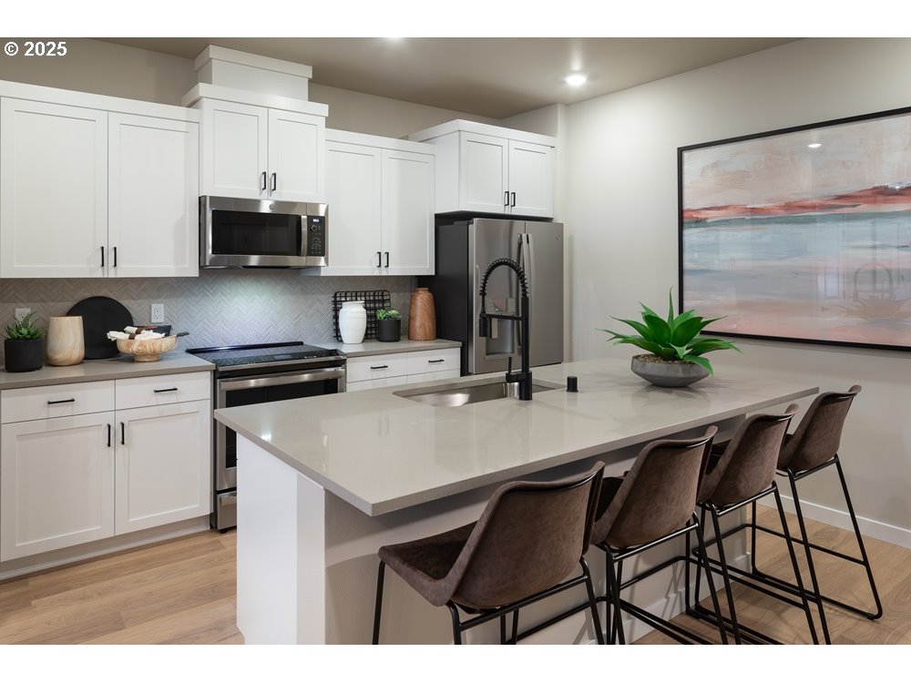 448 Southwest 32nd Street Battle Ground, WA 98604 - Photo 5 of 15 a kitchen with stainless steel appliances a sink a table and chairs