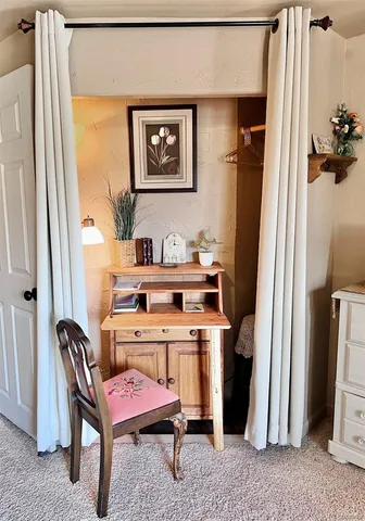 a room with a table chairs and a refrigerator