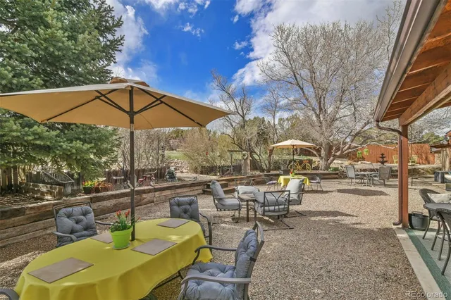a view of a patio with a table and chairs under an umbrella