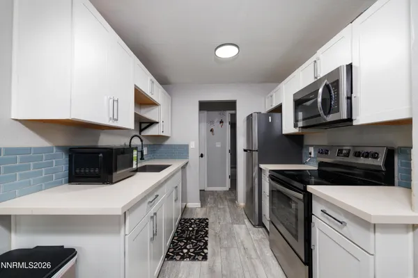 a kitchen with stainless steel appliances a stove a microwave a sink and cabinets