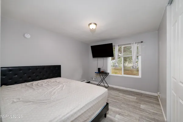 a bedroom with a bed and a flat screen tv