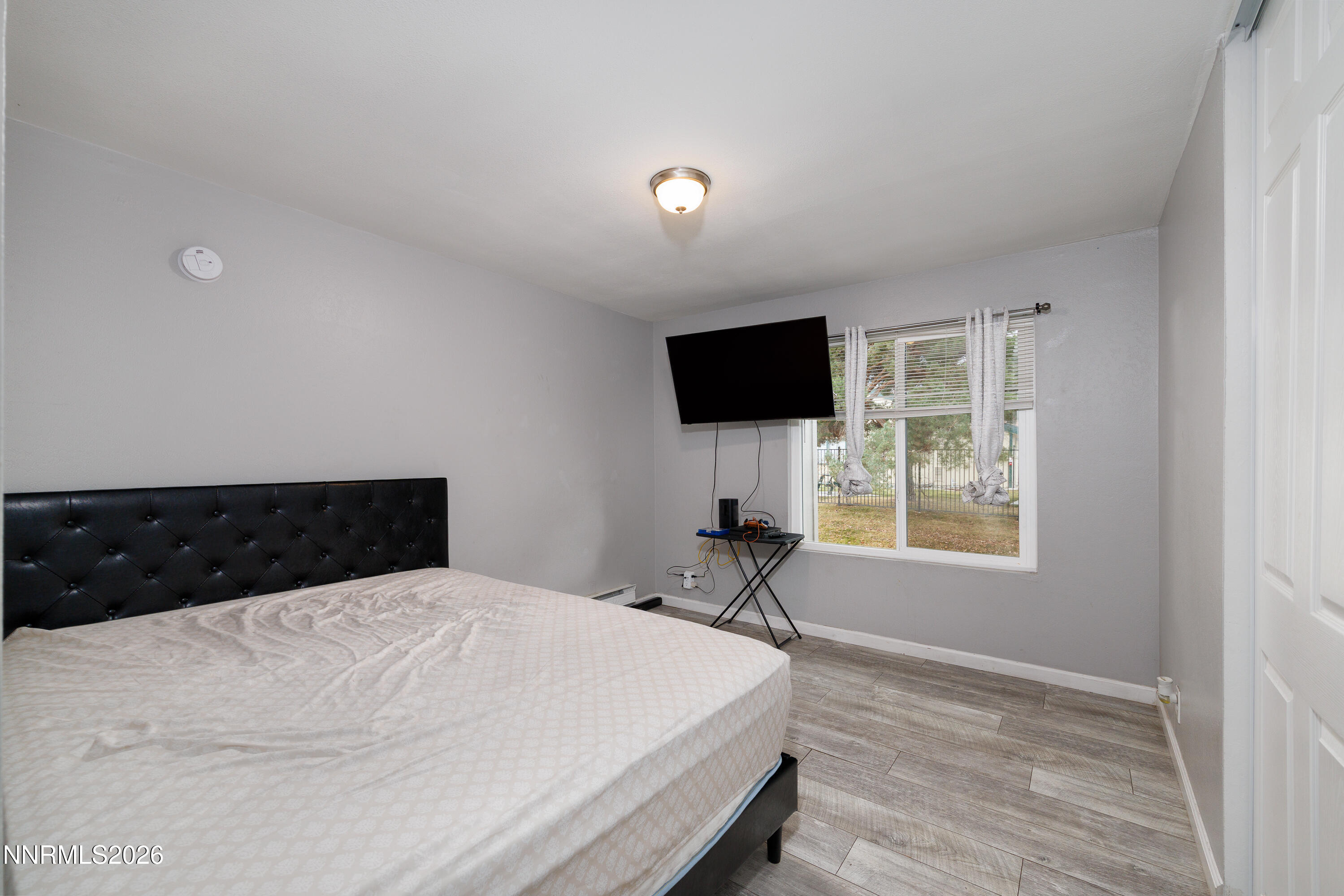 3935 Clear Acre Lane, Unit 214 Reno, NV 89512 - Photo 3 of 15 a bedroom with a bed and a flat screen tv