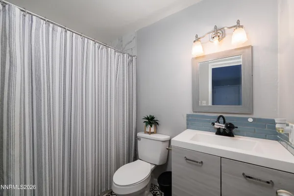 a bathroom with a sink a toilet and mirror