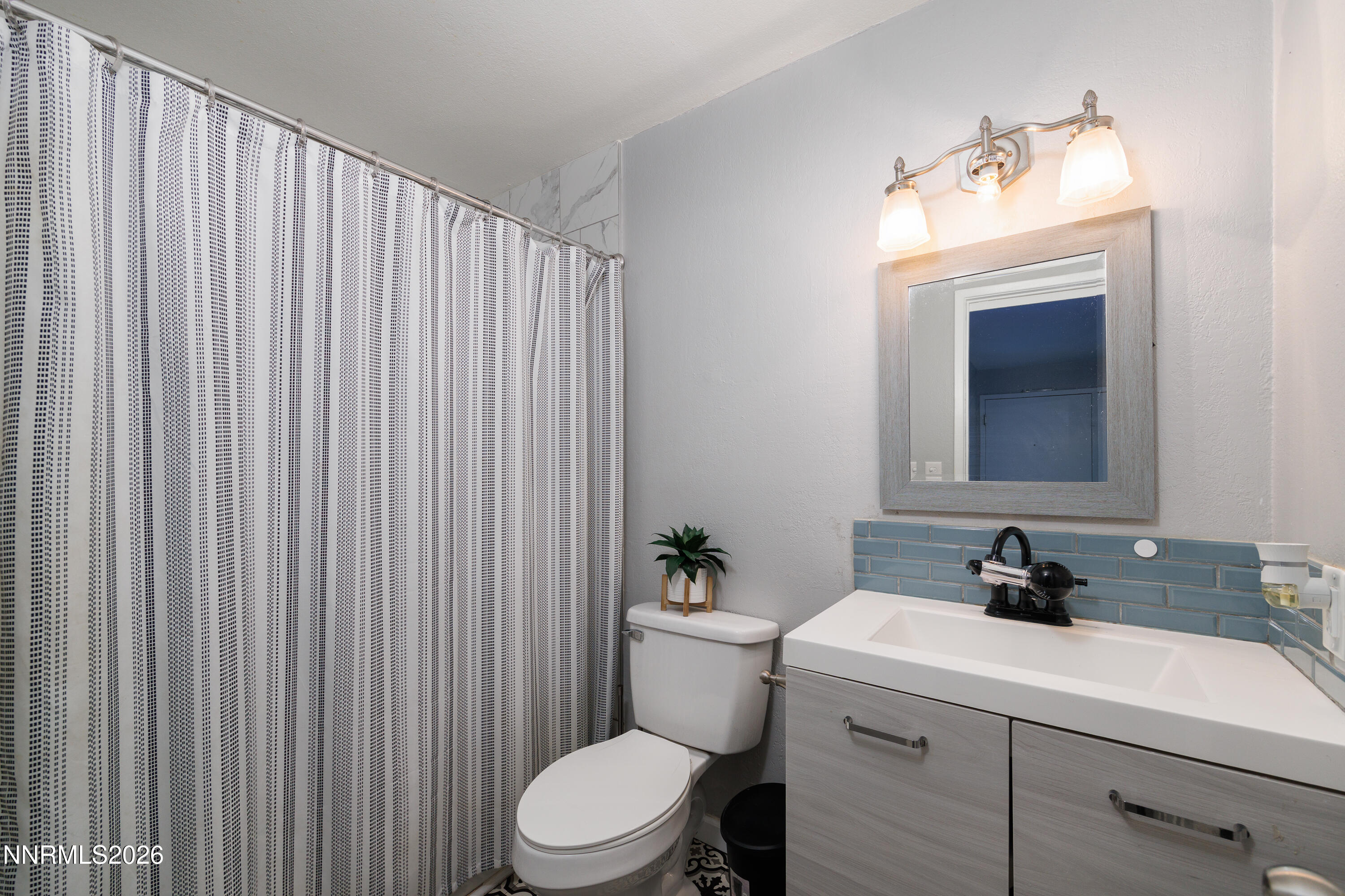 3935 Clear Acre Lane, Unit 214 Reno, NV 89512 - Photo 7 of 15 a bathroom with a sink a toilet and mirror