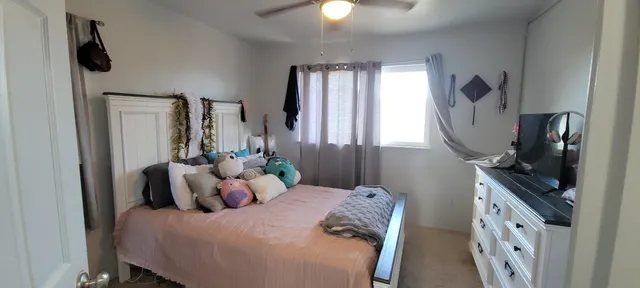 a bedroom with bed mirror and window