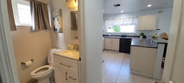 a bathroom with a granite countertop toilet sink and mirror