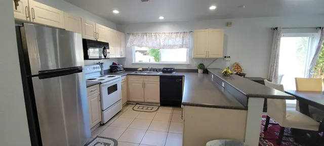 a kitchen with a sink appliances cabinets and a counter top space