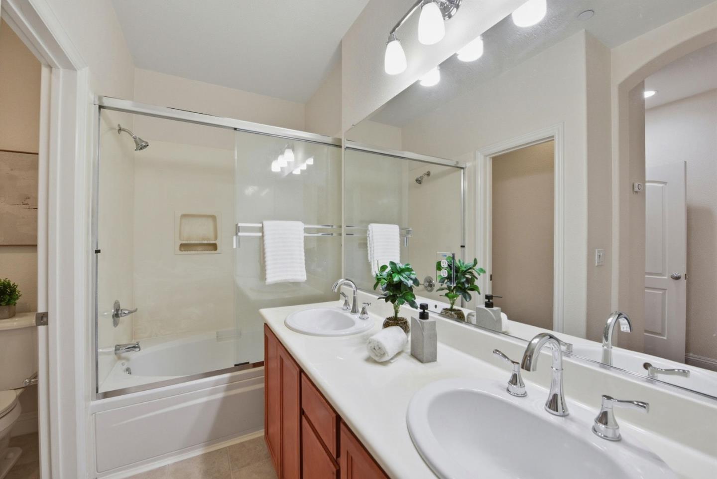 48962 Woodgrove Common Fremont, CA 94539 - Photo 19 of 36 a bathroom with a granite countertop sink a shower and a mirror