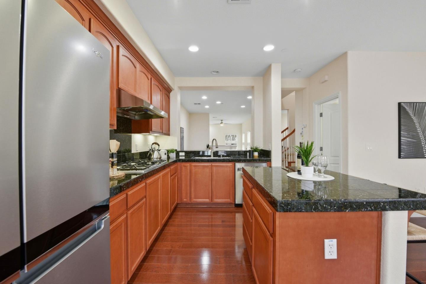 48962 Woodgrove Common Fremont, CA 94539 - Photo 8 of 36 a large kitchen with kitchen island sink stove and cabinets