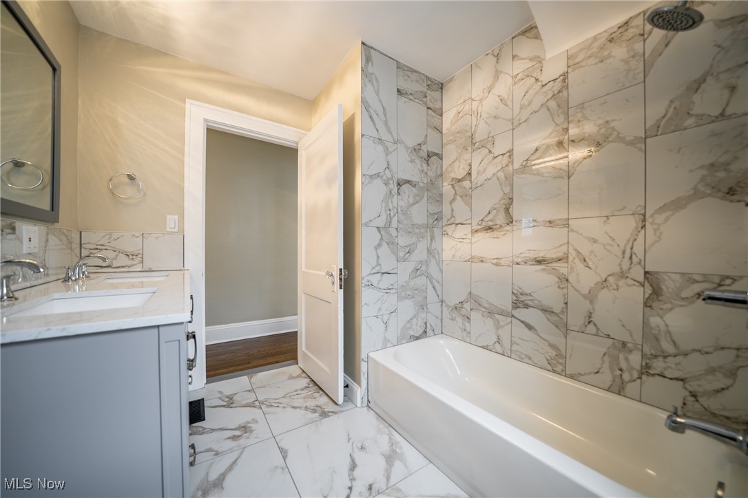 3816 Summit Park Road Cleveland Heights, OH 44121 - Photo 22 of 35 Bathroom with light marble finish floors, double vanity, and a combined bath / shower with marble appearance