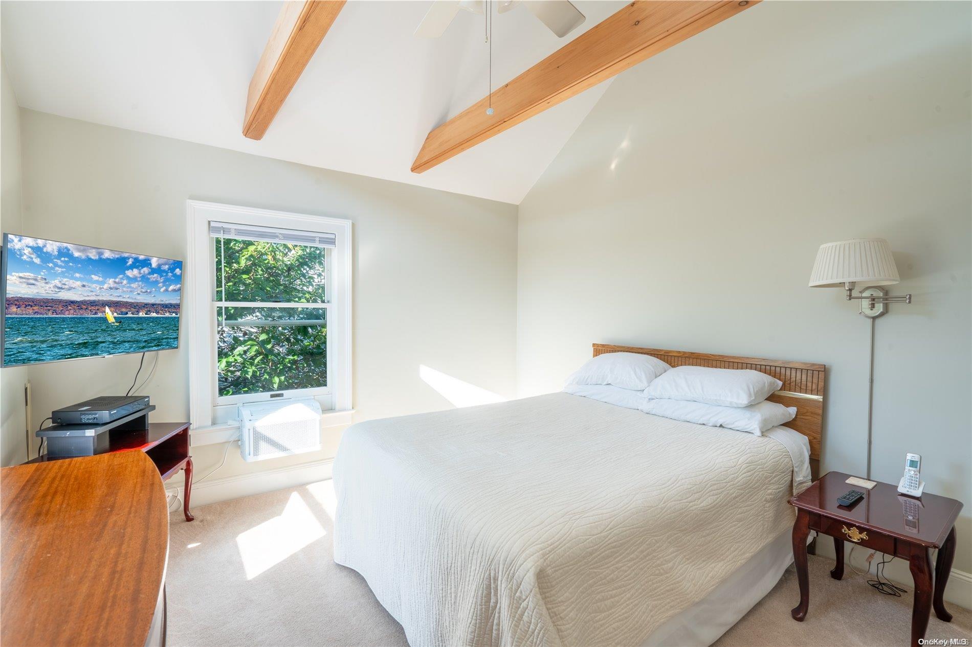 231 5th Avenue Greenport, NY 11944 - Photo 12 of 18 a bedroom with a bed and a window