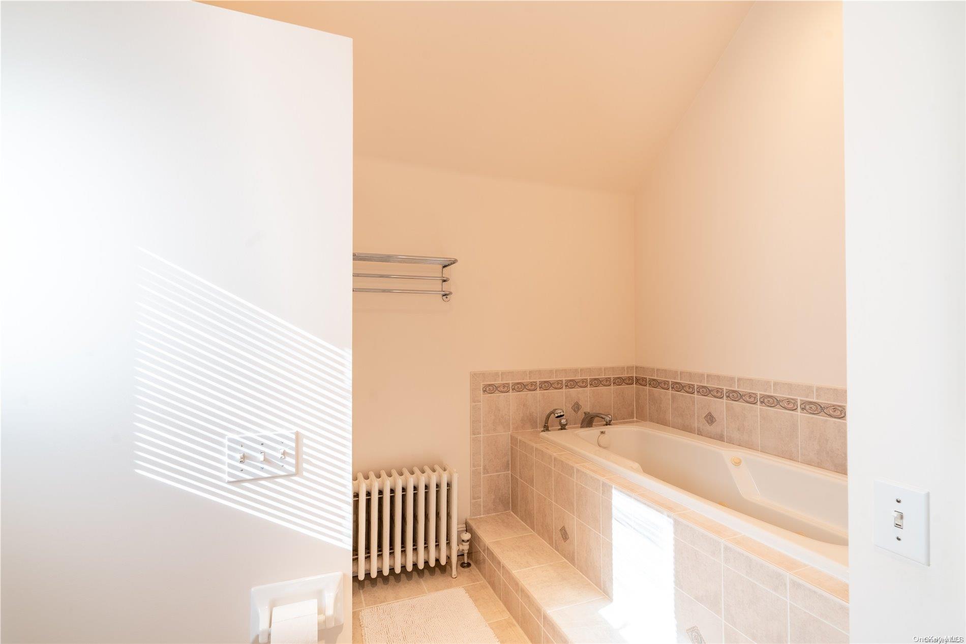 231 5th Avenue Greenport, NY 11944 - Photo 16 of 18 a bathroom with a bathtub and shower