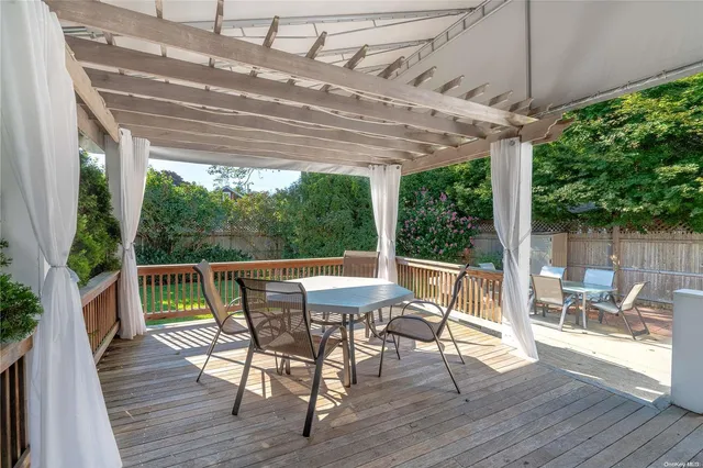 a view of a patio with a table chairs and wooden floor
