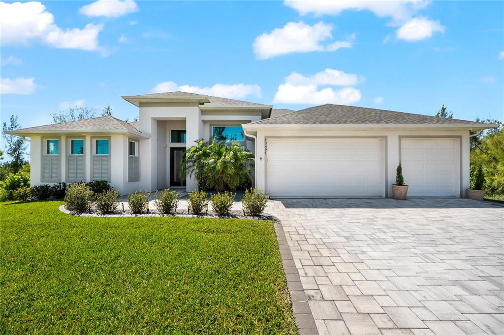 10491 Sarasota Road Port Charlotte, FL 33981 - Photo 2 of 44 a front view of a house with a yard and potted plants