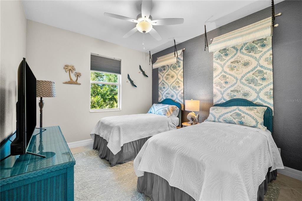 10491 Sarasota Road Port Charlotte, FL 33981 - Photo 21 of 44 a bedroom with two beds and a flat screen tv