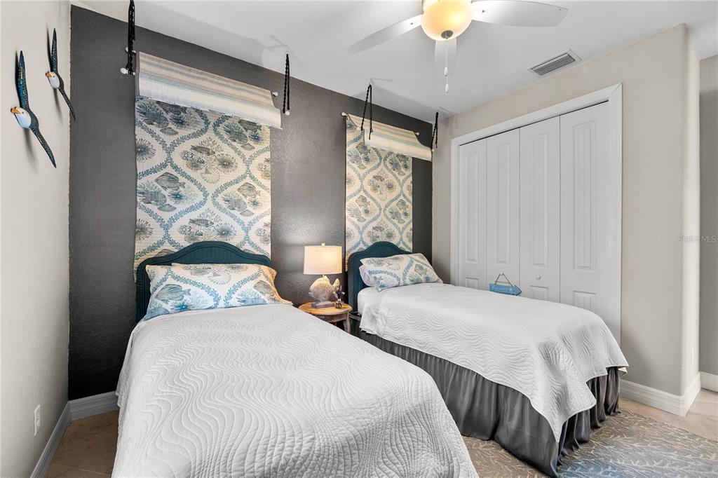 10491 Sarasota Road Port Charlotte, FL 33981 - Photo 22 of 44 a bedroom with two beds and a chandelier