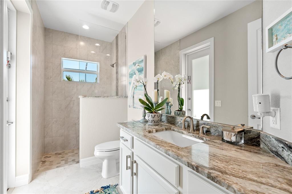 10491 Sarasota Road Port Charlotte, FL 33981 - Photo 23 of 44 a bathroom with a granite countertop sink mirror vanity and toilet