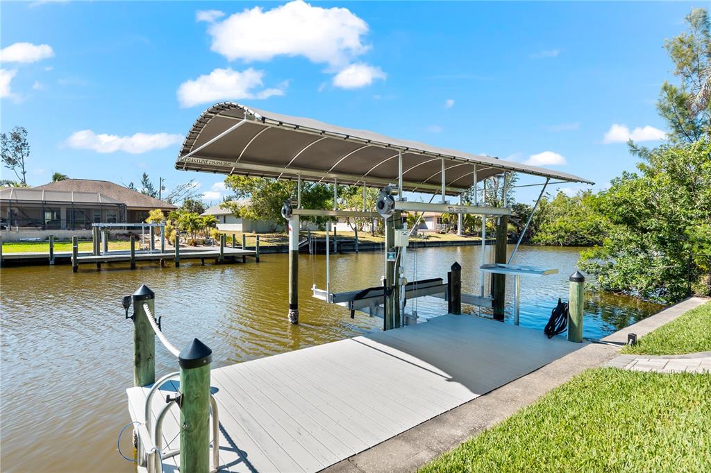 10491 Sarasota Road Port Charlotte, FL 33981 - Photo 38 of 44 a view of a lake with a table and chairs under an umbrella