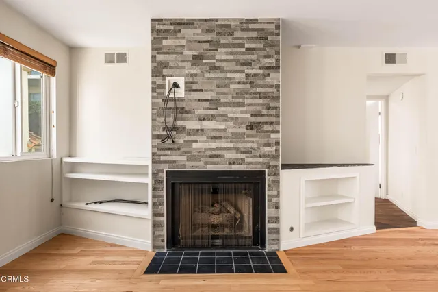 a living room with a fireplace and a walk in closet