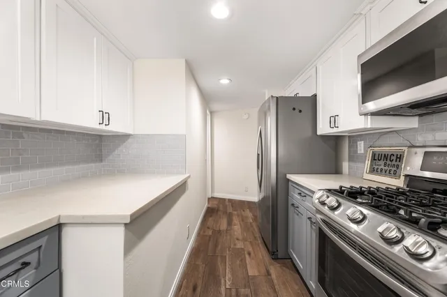 a kitchen with stainless steel appliances a stove a sink and a microwave