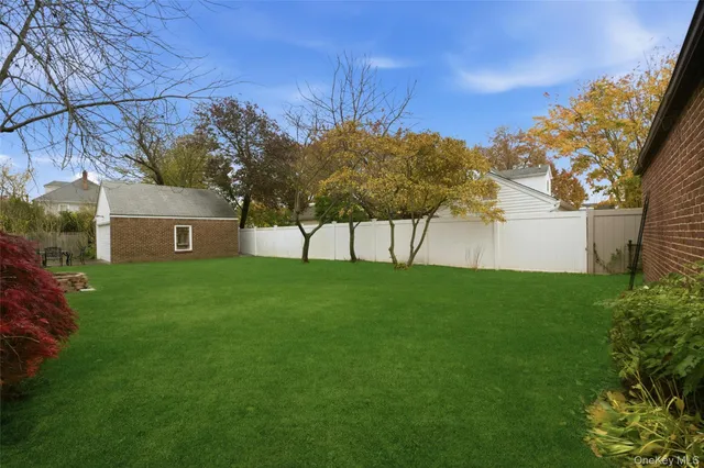 a view of a back yard of the house with a large tree