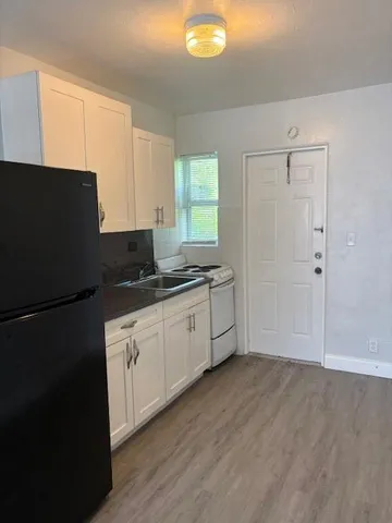 a kitchen with granite countertop a refrigerator a sink and dishwasher