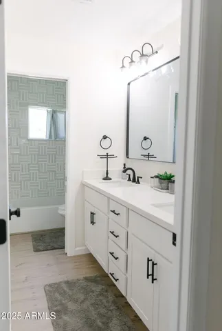 a bathroom with a double vanity sink mirror and shower
