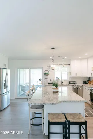 a kitchen with kitchen island a stove a table and chairs in it