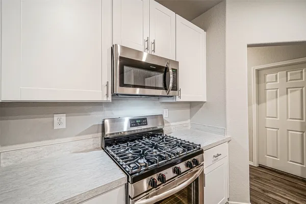 a kitchen with stainless steel appliances granite countertop a stove a microwave and cabinets