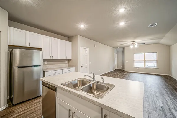 a kitchen that has a sink a refrigerator and window