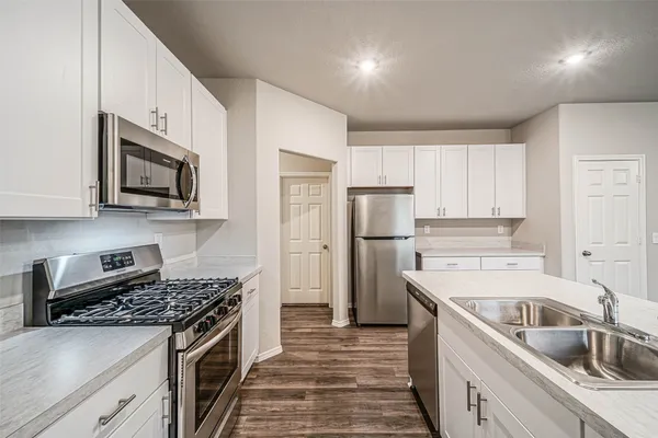 a kitchen with a sink stove and refrigerator