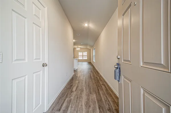 a view of a hallway with wooden floor and staircase