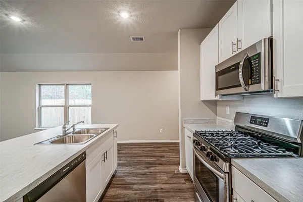 a kitchen with stainless steel appliances granite countertop a sink stove and microwave