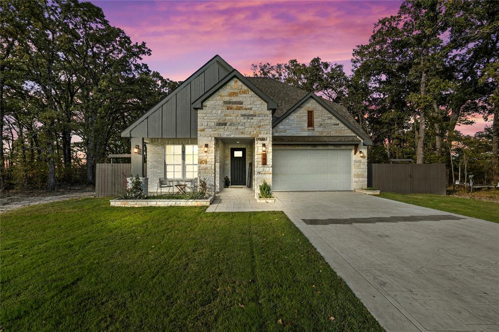 a front view of a house with a garden and trees