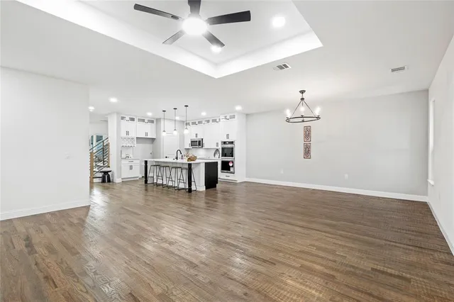 a view of a room with kitchen island stainless steel appliances wooden floor and living room view