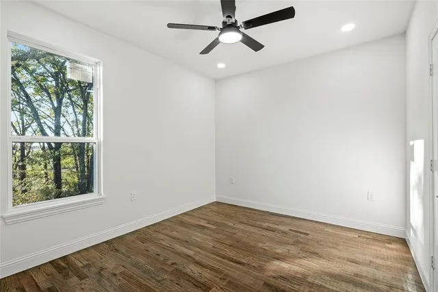 a room with wooden floor and white cabinets