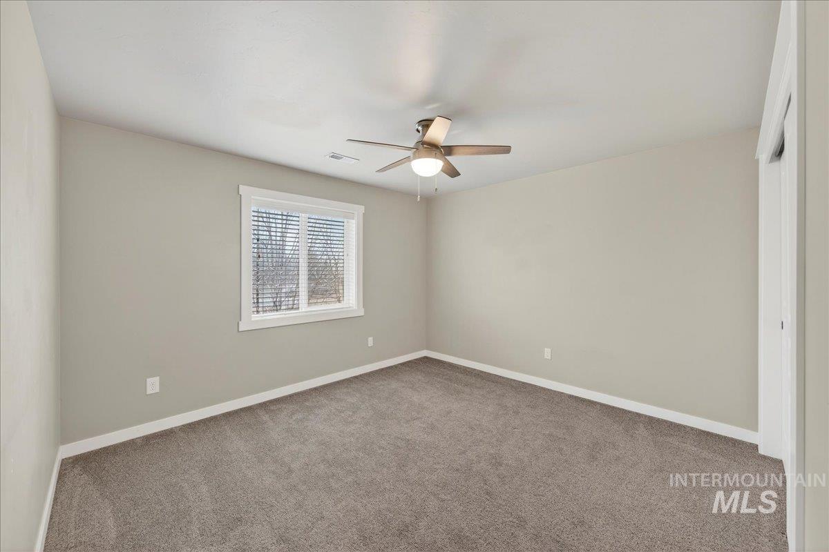 12200 West Oneida Street Boise, ID 83709 - Photo 17 of 35 Carpeted spare room featuring baseboards and a ceiling fan