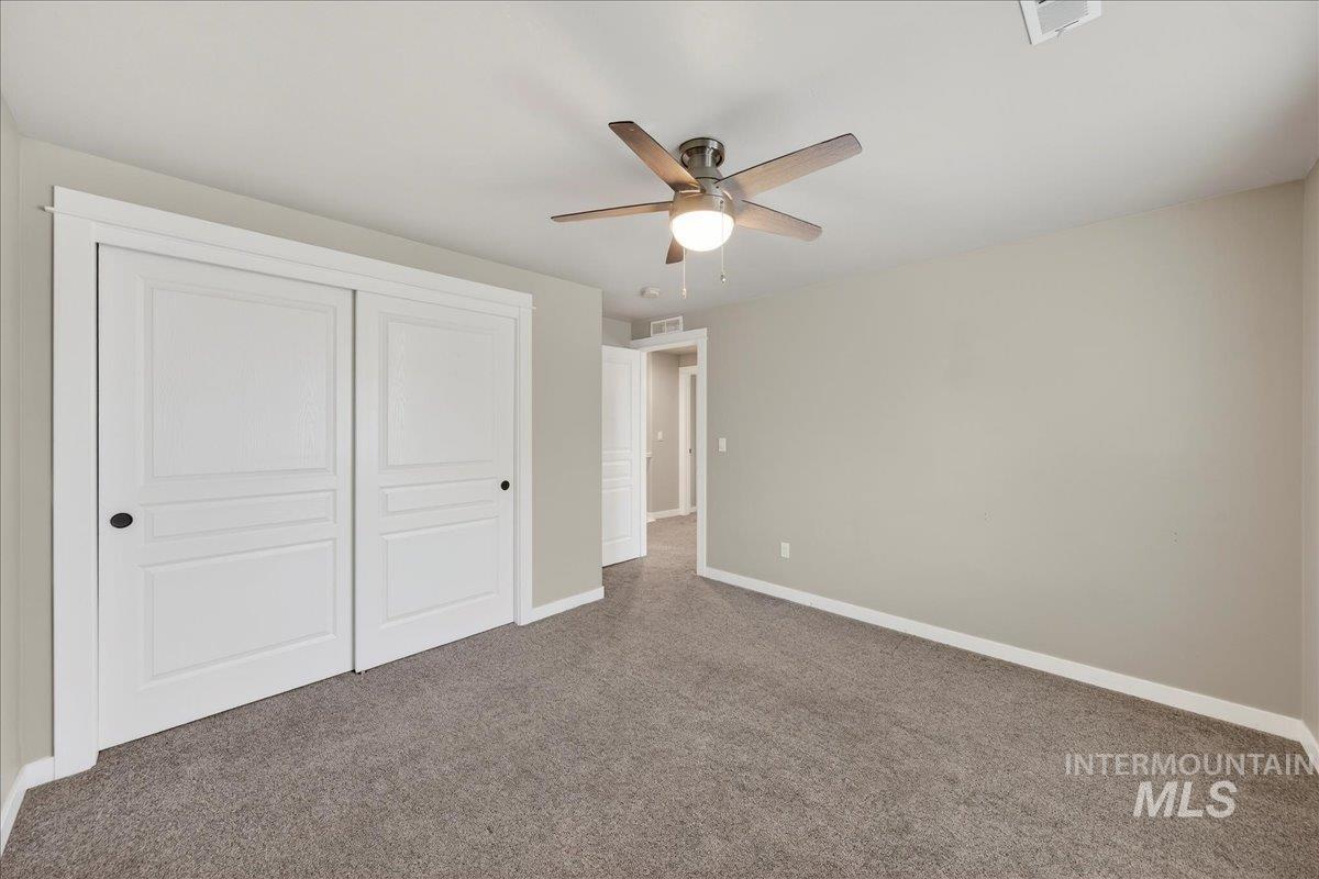 12200 West Oneida Street Boise, ID 83709 - Photo 18 of 35 Unfurnished bedroom featuring a closet, carpet flooring, and ceiling fan