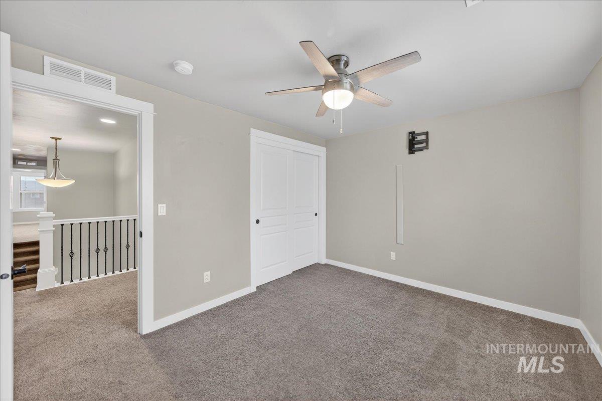 12200 West Oneida Street Boise, ID 83709 - Photo 21 of 35 Unfurnished bedroom with carpet, a closet, and a ceiling fan