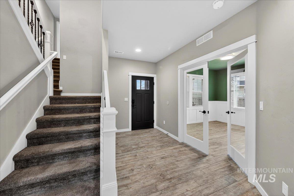 12200 West Oneida Street Boise, ID 83709 - Photo 23 of 35 Foyer entrance with french doors, stairs, light wood-style flooring, and recessed lighting
