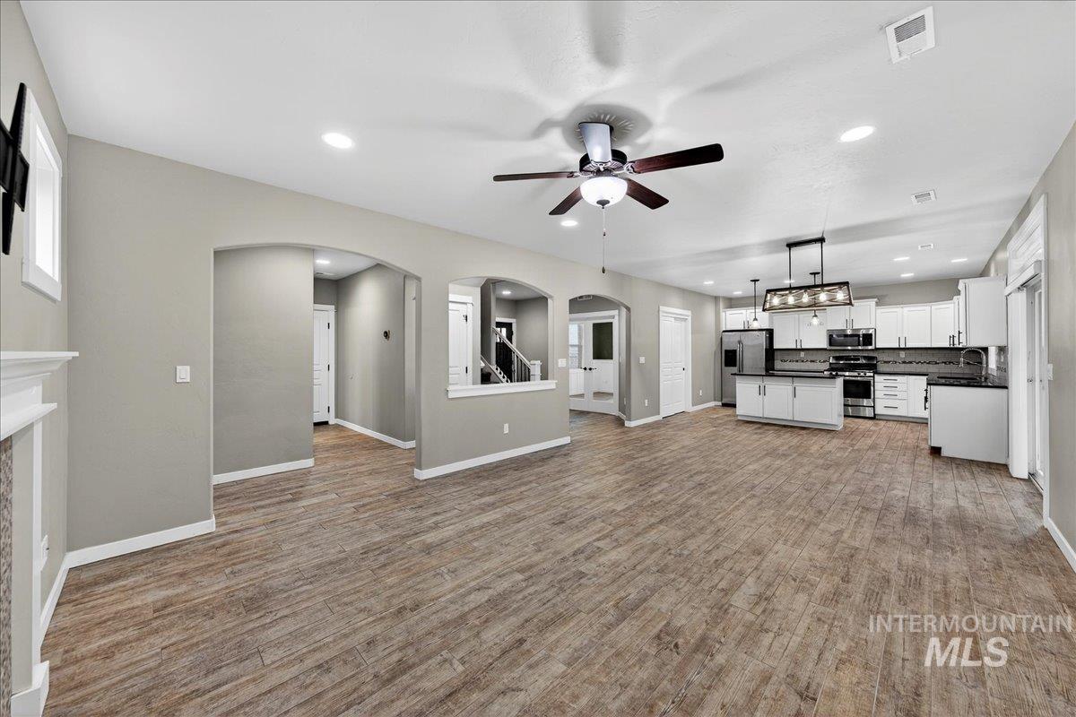 12200 West Oneida Street Boise, ID 83709 - Photo 3 of 35 Unfurnished living room featuring arched walkways, a ceiling fan, recessed lighting, and light wood-type flooring