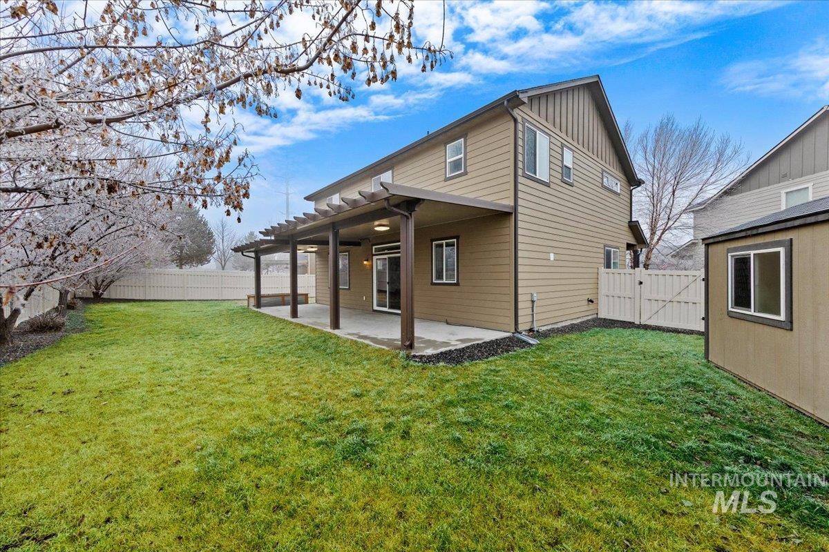 12200 West Oneida Street Boise, ID 83709 - Photo 31 of 35 Back of property featuring a patio area, a gate, a fenced backyard, and board and batten siding