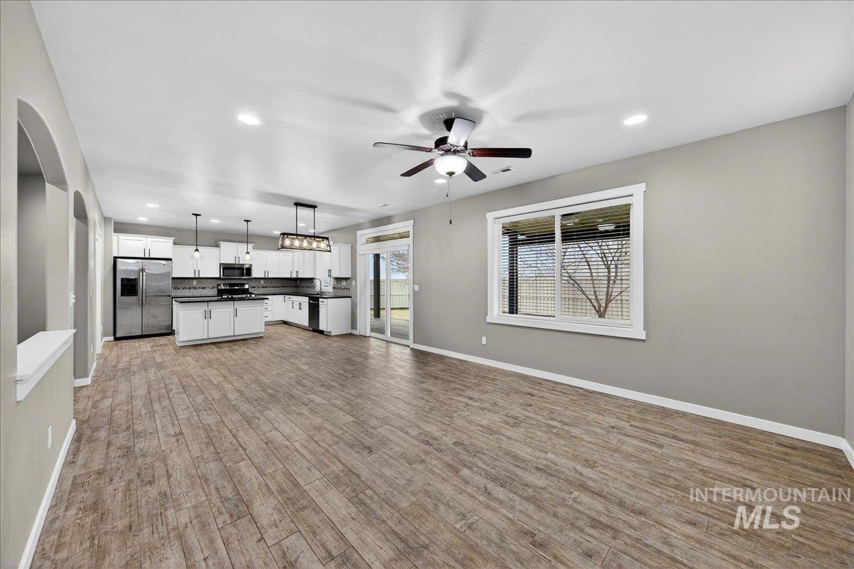 12200 West Oneida Street Boise, ID 83709 - Photo 35 of 35 Kitchen featuring open floor plan, dark countertops, recessed lighting, stainless steel appliances, and white cabinetry