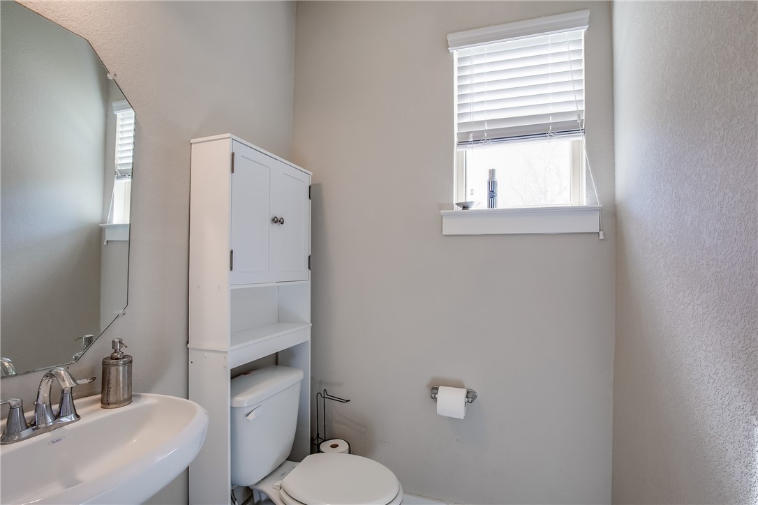 9707 McKnight Loop Austin, TX 78717 - Photo 10 of 17 a bathroom with a toilet a sink a mirror and a window
