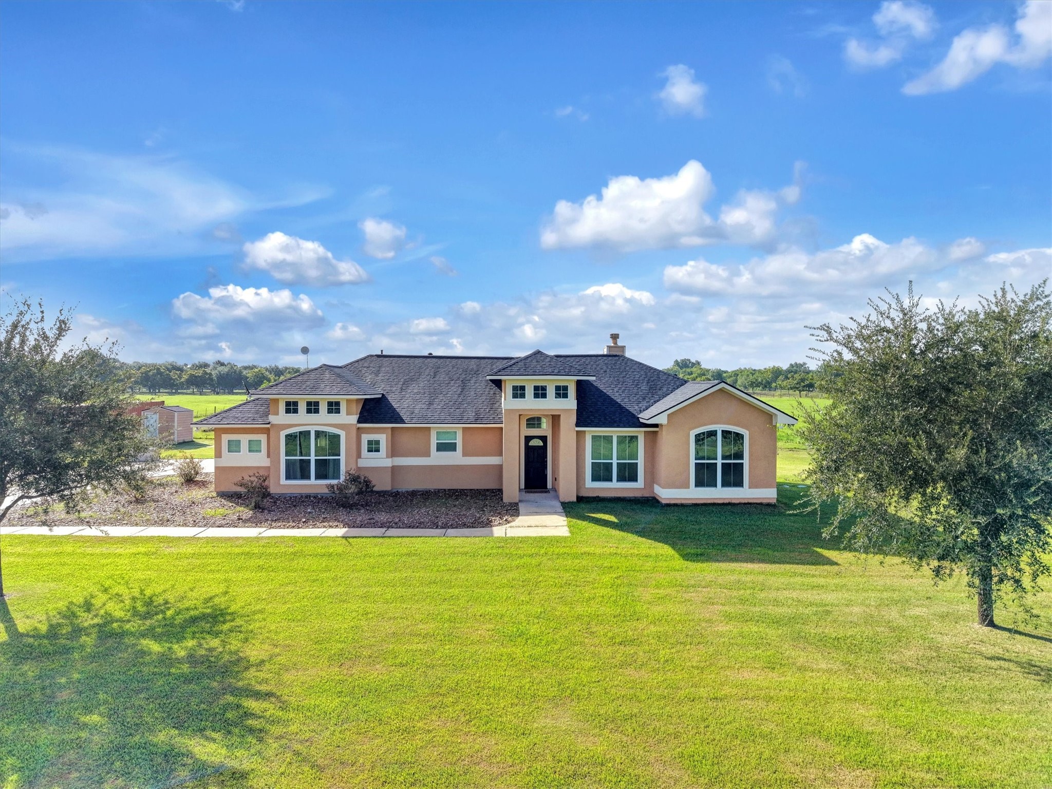 8131 Brinkmeyer Road Needville, TX 77461 - Photo 17 of 49 Charming ranch-style home set on a spacious green lot, featuring a welcoming front entrance and abundant natural light through large windows.