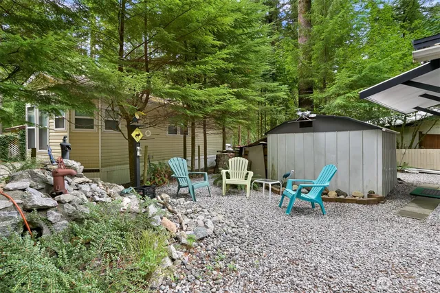 a backyard of a house with dining table and chairs